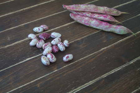 Beans with pods on a wooden table seen close upの写真素材