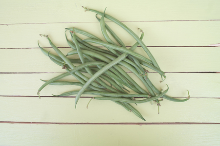 green beans on a green wooden table viewed from aboveの写真素材