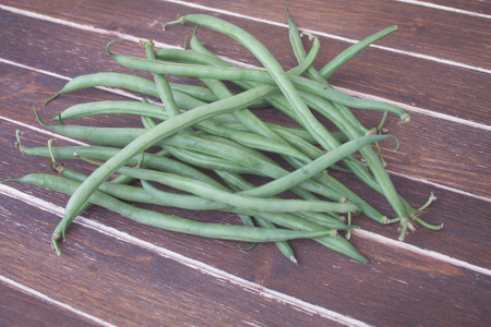 green beans on a wooden table seen close upの写真素材