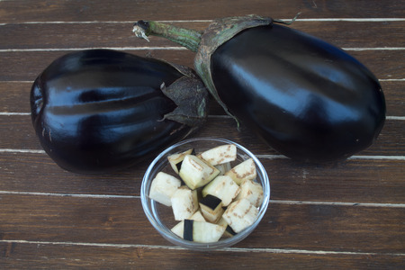 eggplants in cubes on a wooden table viewed from close upの写真素材