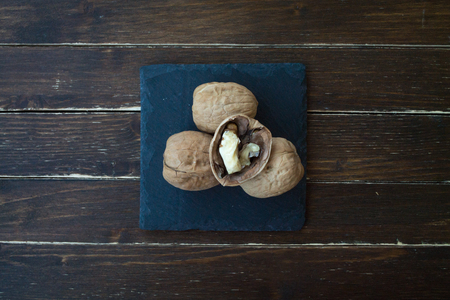 walnuts on a slate plate on a wooden table seen from aboveの写真素材