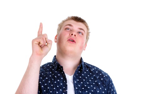 Young man pointing up finger. Isolated on white background, positive human emotion, facial expressionの写真素材