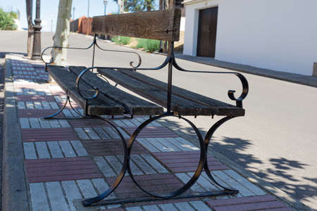 empty wooden and iron people's bench located in a town square
