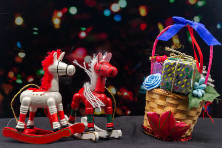Christmas wooden rocking horses and basket with gifts. Christmas ornaments. Christmas. Christmas decoration. Child toyの写真素材