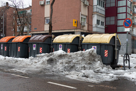Madrid, Spain- January 20, 2021: garbage accumulates in Madrid's containers due to the snow. Dirty Madrid. Urban waste.のeditorial素材