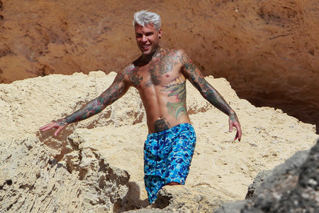 Formentera, Spain- August 12, 2019: The famous rapper Fedez enjoys a vacation in Formentera. Rapper Fedez on the rocks of a cliff. Rapper Fedez swimming in the waters of the Mediterranean Sea.のeditorial素材