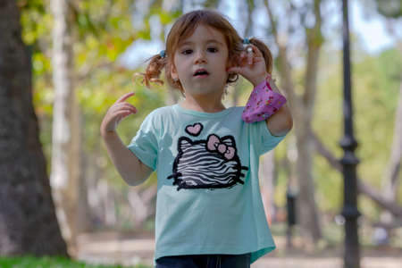 Little blonde girl with face mask in the park