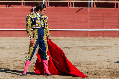 Madrid, Spain- April 30, 2022: Bullfight in San Martin de Valdeiglesias. Bullfighter with a crutch. Fighting bull. Bullfighter giving a muleta pass to the bull in a bullring.のeditorial素材