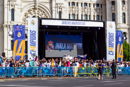 Madrid, Spain- May 29, 2022: Real Madrid CF celebrates its 14th European Championship in Madrid. Team fans wave flags and scarves as the bus passes with the players.のeditorial素材