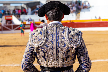 Madrid, Spain- June 19, 2022: Bullfight in the town of Villarejo de SalvanÃ©s. Bullfighter with jacket and montera with his back to the camera.のeditorial素材