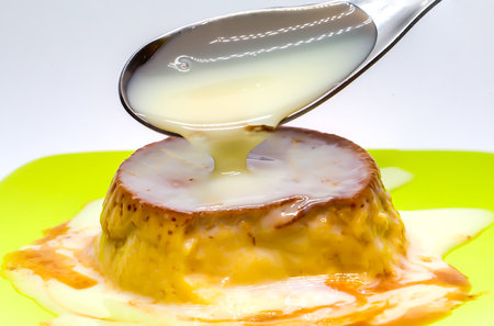 Egg flan with condensed milk. Teaspoon with condensed milk. Sweet condiment for desserts. Sugar desserts. Sugary foods.の写真素材