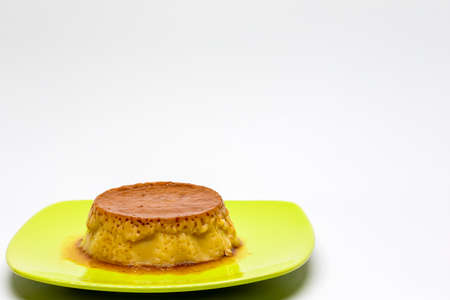 Egg custard on green plate. Sugar desserts. Sugary foods. Side photo.の写真素材