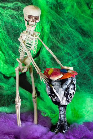 Halloween parties. Standing skeleton holding a cup full of candy. Day of the Dead. Mexican festivals.の写真素材