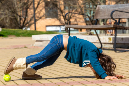 Blonde little girl in sweatshirt and scarf. 3 year old blonde girl. Children in the park. Funny photos.の写真素材