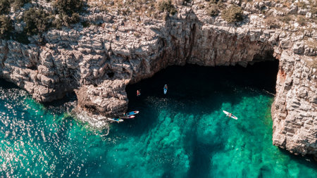 Beautiful rocky beach with SUP stand up paddle boards and with turquoise water in Montenegro. View from above with droneの写真素材