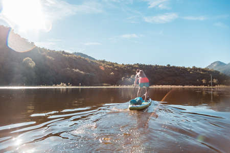 Young athletic man SUP stand up paddle board in Rijeka Crnojevica river in Skadar Lake National Park. One of the most famous views of Montenegroの写真素材