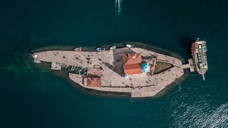 Our Lady of the Rock island and Church in Perast on shore of Boka Kotor bay (Boka Kotorska), Montenegro, Europe. Aerial view with stand up paddle boards and touristsのeditorial素材