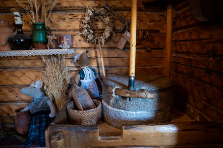 A rustic cabin interior showcases a stone mill, dried floral wreaths, and vintage ceramic and...