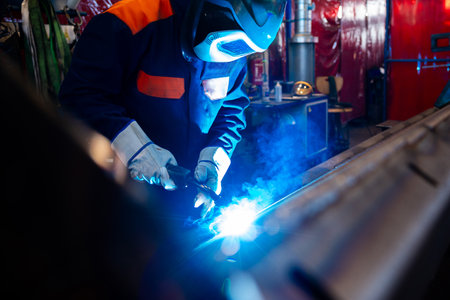 Metal welding steel works using electric arc welding machine to weld steel at factory. Metalwork...