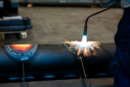 Heating up of metal construction with acetylene and oxygen burner in process of flame straightening with visible red colour of heated metalの写真素材