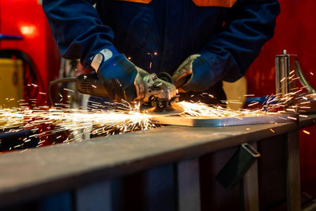 Sawing the metal with a grinder. metal works in factory