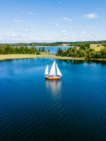 Aerial view of a modern sailing yacht sails on the sea surface, lake on sunny summer day.の写真素材