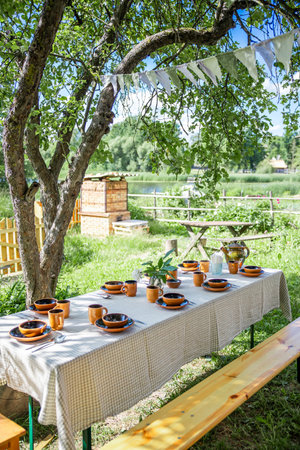 a table with beautiful earthenware in the yard on a sunny summer dayの写真素材