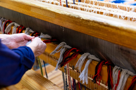 Woman is warping a wooden handloom. Hands holding a heddle hook and threading the table loom. Weaving toolsの写真素材