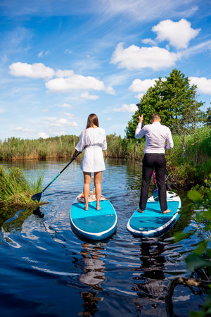 Young attractive couple on stand up paddle board in the lake, SUPの写真素材
