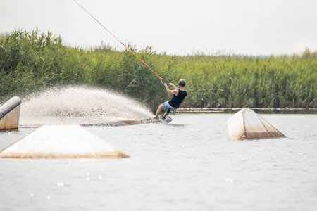 Wakeboarding and water sports activity.  Man wakeboarding on a lake. Man water skiing in summerの写真素材