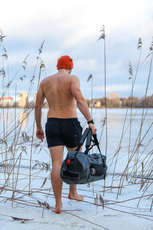 winter swimming enthusiast prepares for a chilly dip in the river, showcasing determination and strength amidst the sereneの写真素材