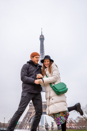 Joyful couple dancing in front of the Eiffel Tower, a romantic and playful moment captured in the heart of Parisの写真素材