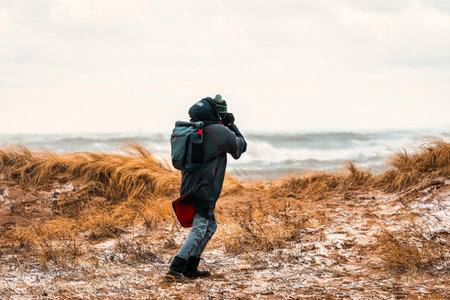 adventurous photographer captures the raw beauty of a coastal storm in winterの写真素材