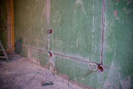 Abandoned building interior in disrepair with debris, exposed pipes, and missing doors awaiting renovationの写真素材