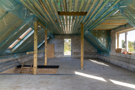 Spacious attic under construction with thermal insulation and skylights in a new homeの写真素材