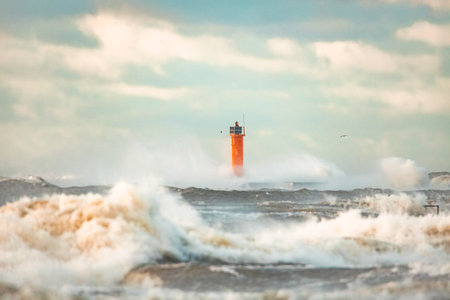 Lighthouse on the sea during Stormy weather in Riga, Latvia. Huge waves crashing down the coast