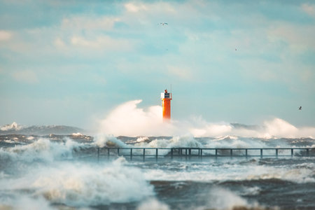 Lighthouse on the sea during Stormy weather in Riga, Latvia. Huge waves crashing down the coastの写真素材
