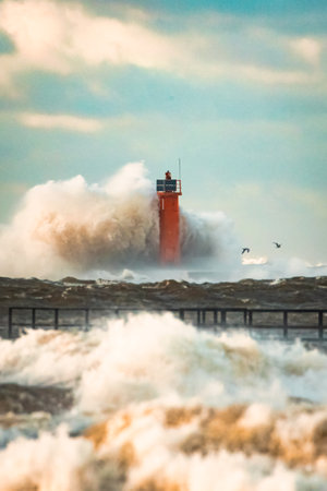 Close up Huge waves crashing lighthouse during the storm. Stormy weather in Riga, Latviaの写真素材