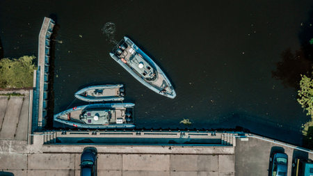 Aerial view of a military boat docked in a harbor alongside other vessels, showcasing the synergy of defense and civilian maritime worldsの写真素材