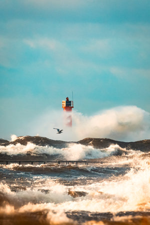 Close up Huge waves crashing lighthouse during the storm. Stormy weather in Riga, Latviaの写真素材