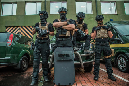 Elite tactical unit ready for operation, fully equipped special forces officers with modern gear against urban backgroundの写真素材