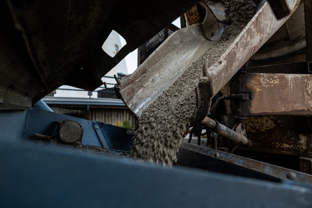 Close-up of Concrete Pouring from a Mixer Truck Chute into a Foundation at a Construction Siteの写真素材