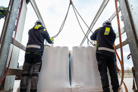 Logistics Professionals Operating a Crane to Lift Heavy Industrial Goods for Transport