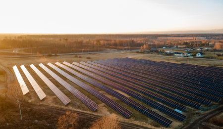 Aerial view of industrial sized solar panel farm during sunset,  illustrating the blend of technology and natureの写真素材