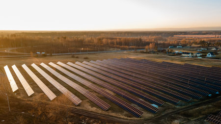 Aerial view of industrial sized solar panel farm during sunset,  illustrating the blend of technology and natureの写真素材