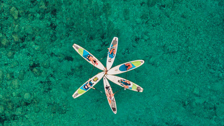 aerial view of a group of paddleboarders forming a star pattern on the clear blue watersの写真素材
