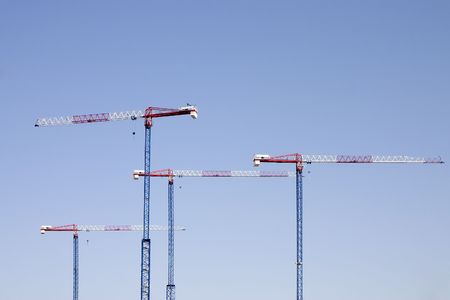 Construction tower cranes against a blue skyの写真素材