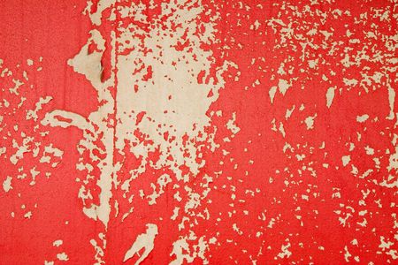 A concrete wall with peeling red paintの写真素材
