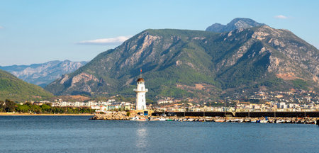 Turkey, Alanya - November 9, 2020: The old lighthouse in the port of Alanya against the backdrop of beautiful mountains. View from the sea.のeditorial素材