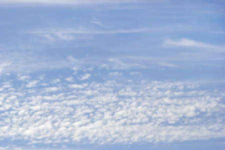 Background of white fluffy clouds on the background of soft blue sky.